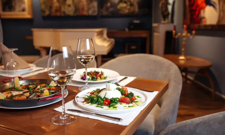 Un dîner romantique dans un restaurant sur Tours. Paella et burrata fraîchement préparées, accompagnées de vin blanc.
