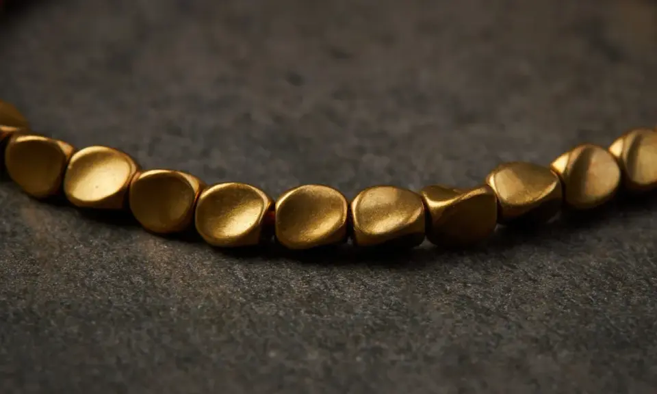 Un bracelet en cuivre aux perles dorées, parfait pour apprendre comment nettoyer un bracelet en cuivre et lui redonner son éclat.