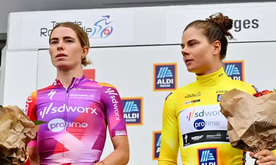Lotte Kopecky auf dem Podium, sie trägt ein pink-violettes Trikot. Neben ihr eine Fahrerin im gelben Trikot.