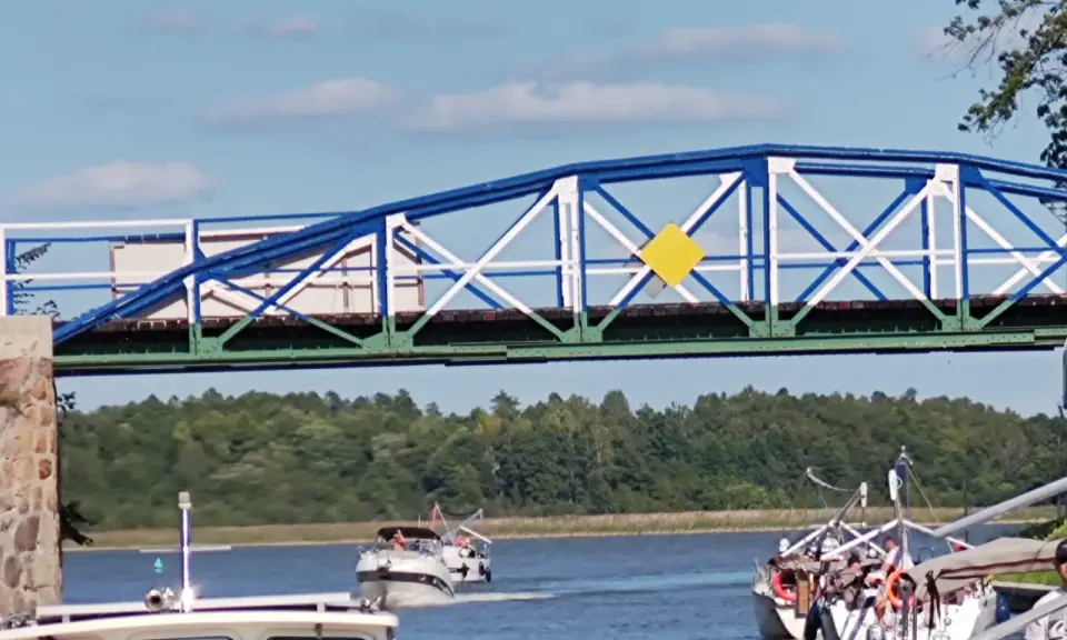 Żółty romb na niebiesko-białym moście to jeden z znaków kardynalnych na wodzie, wskazujący drogę wodną.