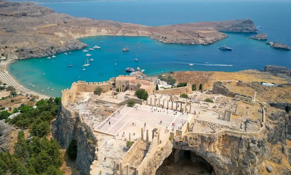 Akropol w Lindos na Rodos, z widokiem na turkusową zatokę i plażę. Wspaniałe ruiny przypominają o dawnej świetności, a nie o koszmarze.