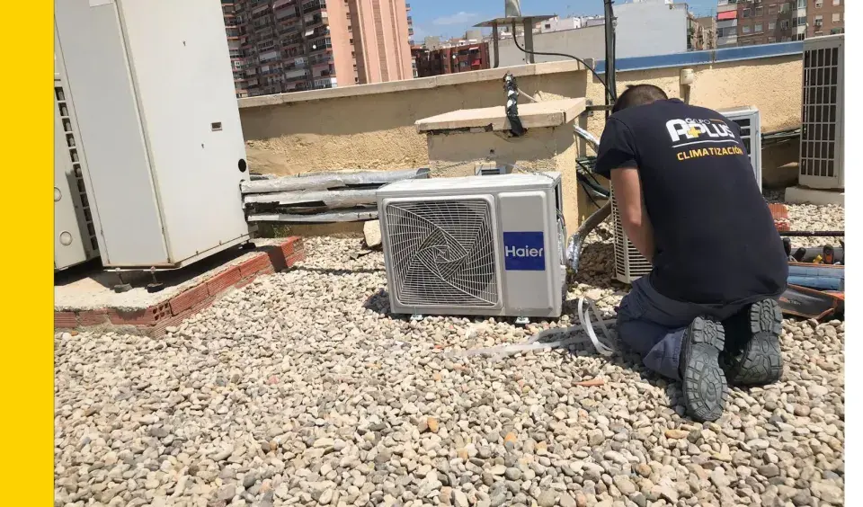 Técnico realizando mantenimiento preventivo de aire acondicionado en una azotea.