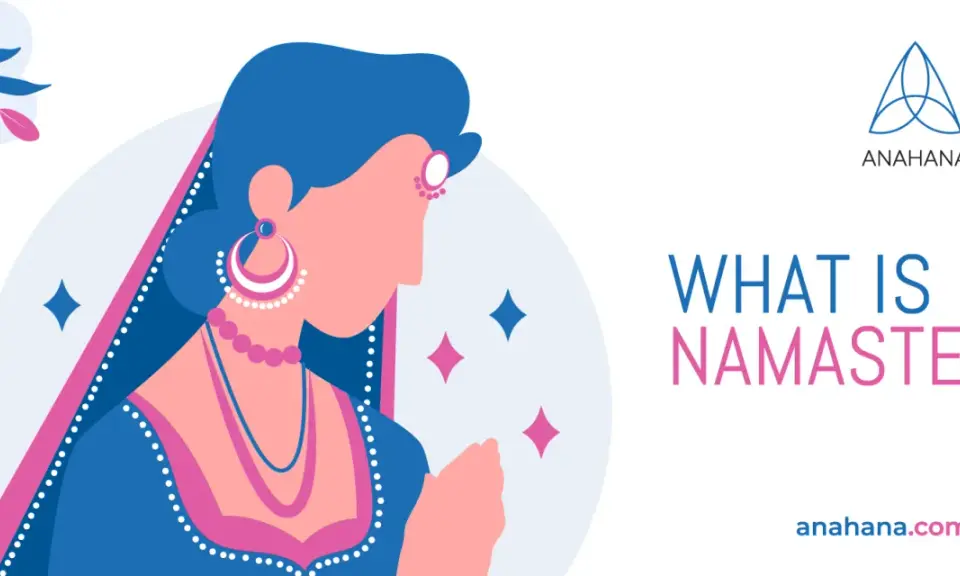 En kvinna i traditionell indisk klädsel med händerna i bön, som illustrerar vad namaste betyder.