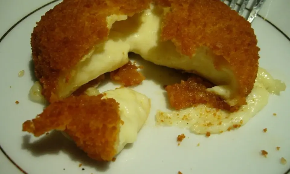 Pyszny camembert w panierce, z którego wypływa gorący, ciągnący się ser. Idealna przekąska na ciepło.