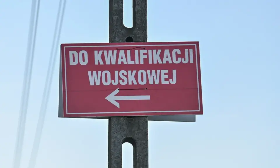 Czerwony znak z białym napisem "DO KWALIFIKACJI WOJSKOWEJ" i strzałką w lewo. Kategoria: d wojsko.