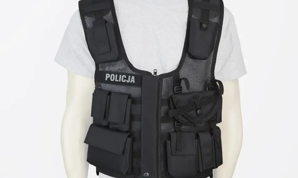 Czarna kamizelka taktyczna z napisem POLICJA, pełna kieszeni i przegródek, gotowa na każde zadanie.