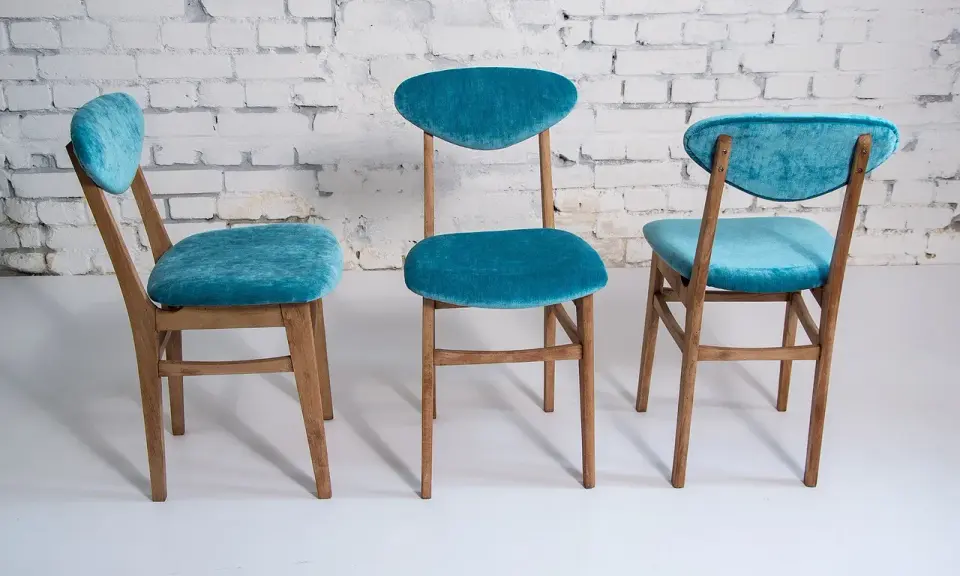 Trois chaises en bois relookées avec un tissu bleu turquoise velouté. Une belle idée déco pour transformer de vieilles chaises.