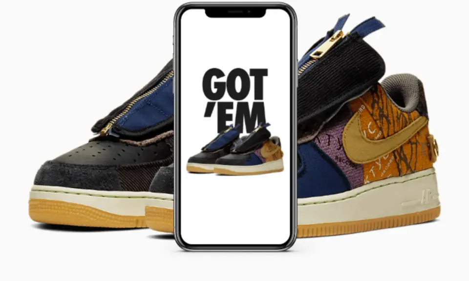Ein Handy zeigt "GOT 'EM" über einem Paar Travis Scott Air Force 1. Das ist, was ist ein raffle, wenn man diese begehrten Sneaker ergattert!