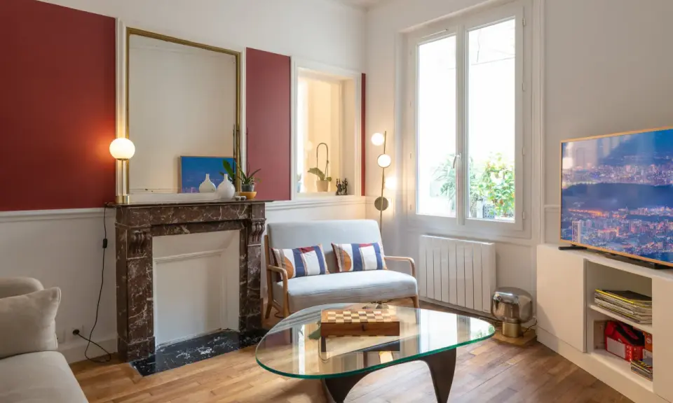 Plan salon 16m2 : cheminée en marbre, canapé gris, table basse en verre avec jeu d'échecs, fenêtre lumineuse.