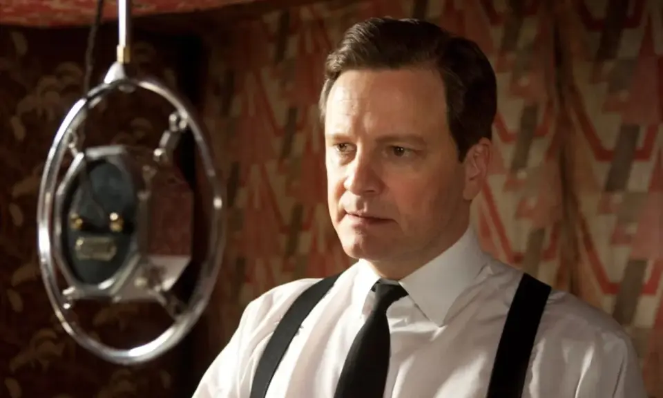 Colin Firth i en vit skjorta med hängslen och slips, nära en mikrofon. En scen från filmer och tv-program med Colin Firth.