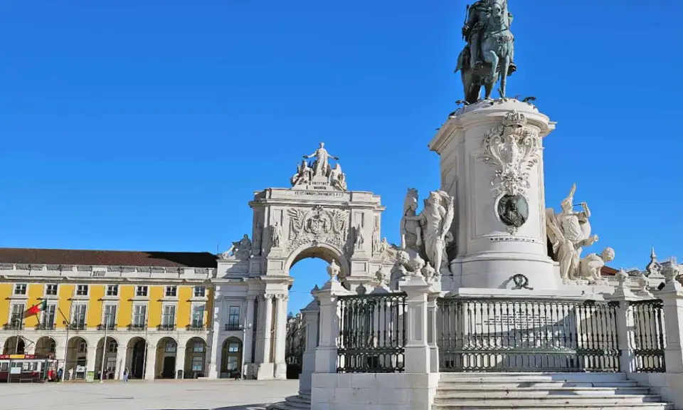 Reiterdenkmal und Triumphbogen am Praça do Comércio in **Baixa Lissabon** unter strahlend blauem Himmel.