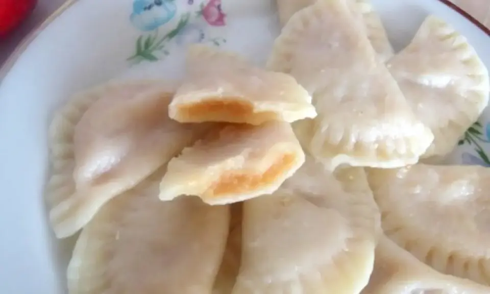 Pyszne pierogi z jabłkami, jeden rozkrojony ukazuje słodkie nadzienie.