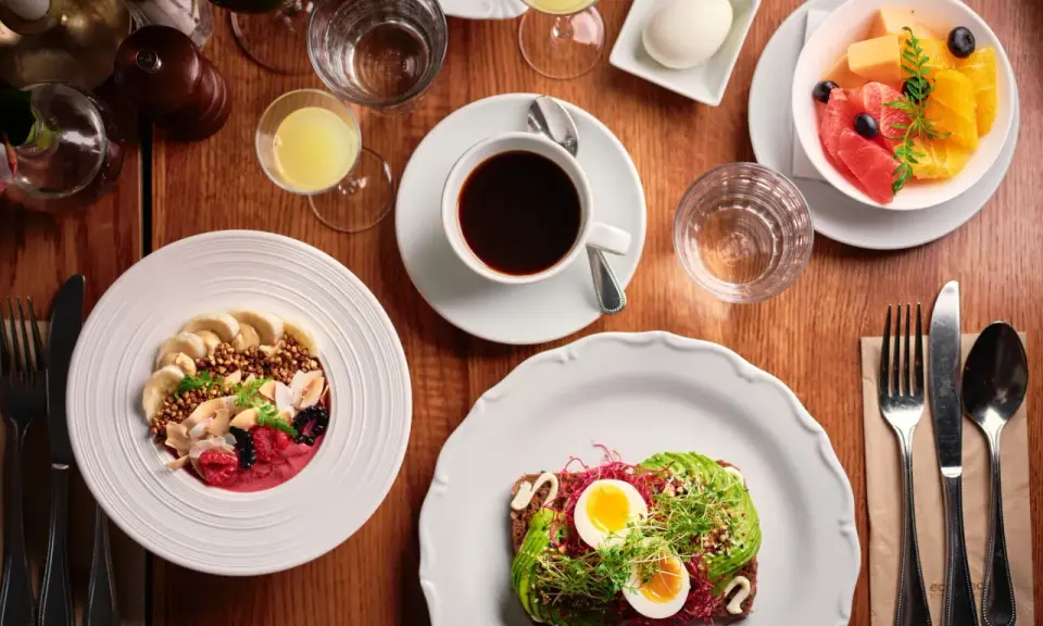 En härlig frukost i Stockholm med en smoothie bowl, avokadotoast, frukt och kaffe.