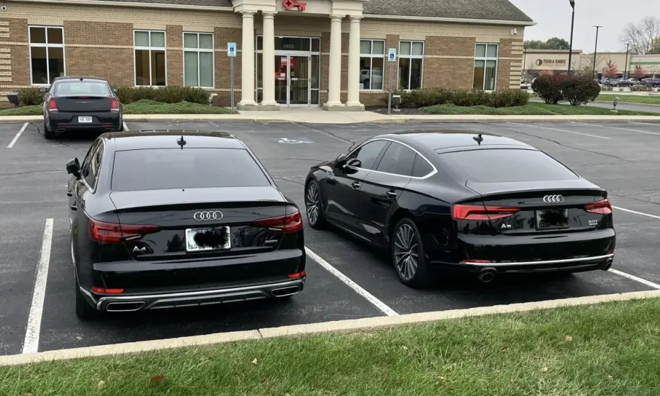 Dos Audis negros, un A4 y un A5, aparcados uno al lado del otro.