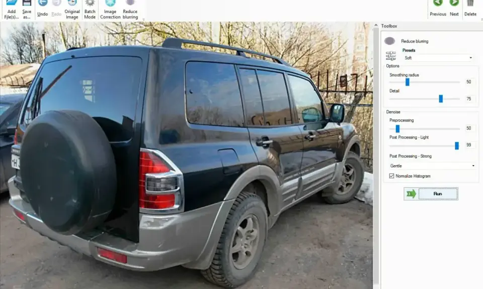 Software per correggere foto mosse. L'immagine mostra un SUV nero con una ruota di scorta sul retro, pronto per essere elaborato.