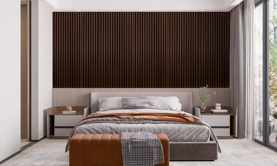 Sovrum panel inspiration: mörka träpaneler bakom en säng med grå sängkläder och en brun pall.