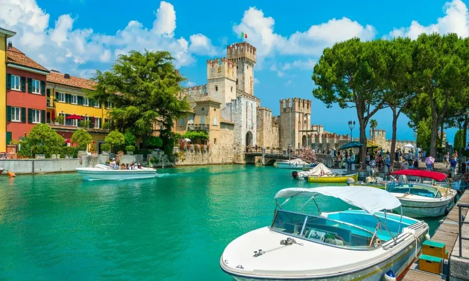 Malowniczy rejs po Jeziorze Garda. Woda lśni, a zamek Scaligero w Sirmione zaprasza do zwiedzania.