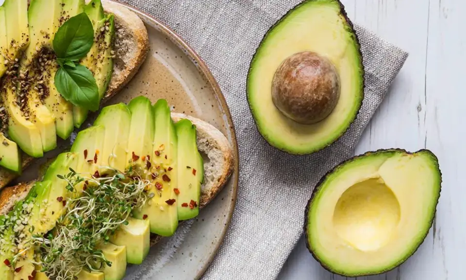 Tostadas de aguacate con brotes y especias. El aguacate, rico en grasas saludables, es un alimento nutritivo.