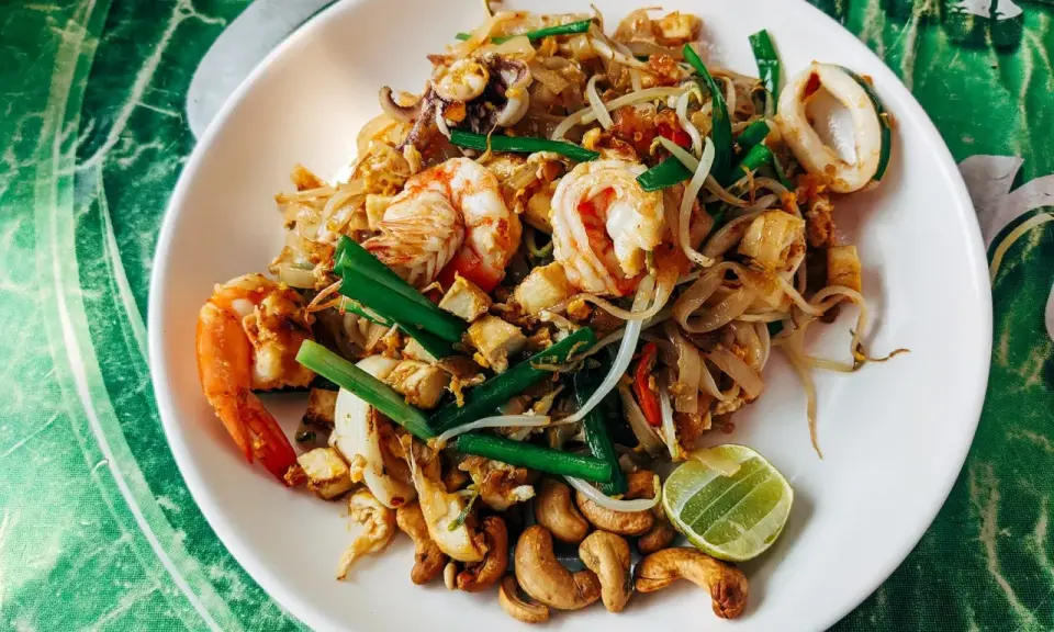 Pyszny pad thai przepis z krewetkami, kalmarami, kiełkami i orzechami nerkowca.