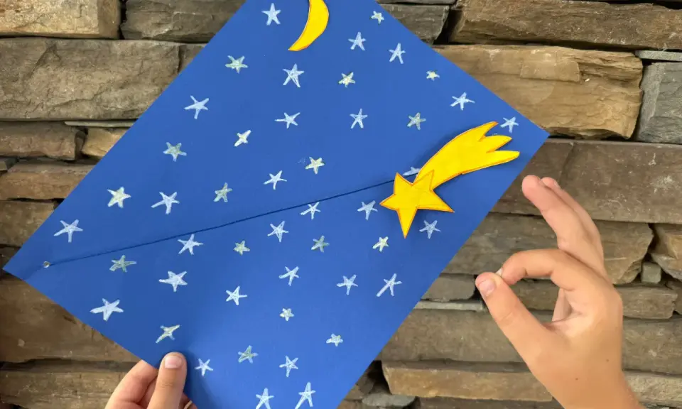 Un cielo blu con stelle e luna, una stella cometa gialla. Un lavoretto per bambini, stella di natale.