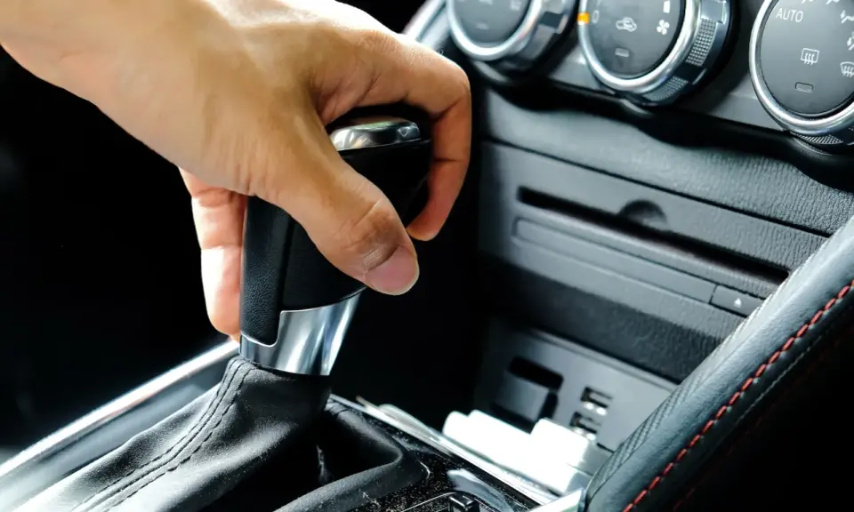 Mano operando la palanca de **cambio automático como funciona** en un coche moderno.