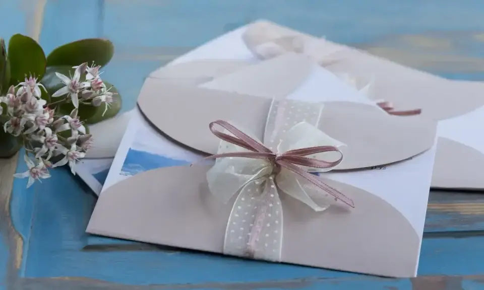 Eleganckie zaproszenia ślubne z kokardkami. Jak odmówić wesele, gdy nie możesz przybyć? Delikatne kwiaty dodają uroku.