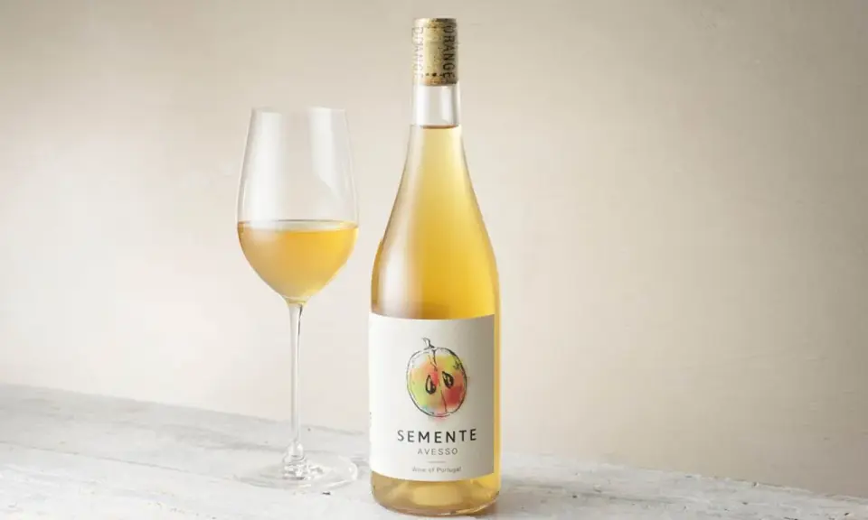 En flaska och ett glas med gyllene Semente Avesso vin.