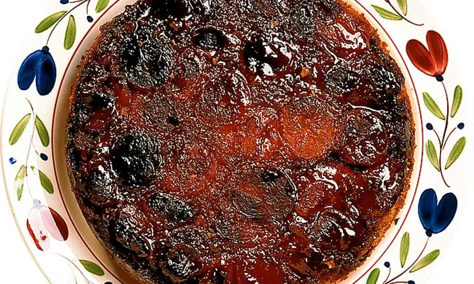 En härlig aprikoskaka upp och ner, med karamelliserad yta och saftiga aprikoser, serverad på en vackert dekorerad tallrik.