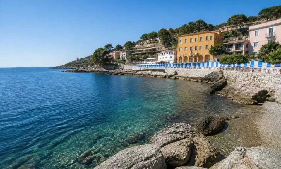 Acque cristalline e case colorate lungo la costa, un angolo di paradiso tra le calette di Porto Santo Stefano.