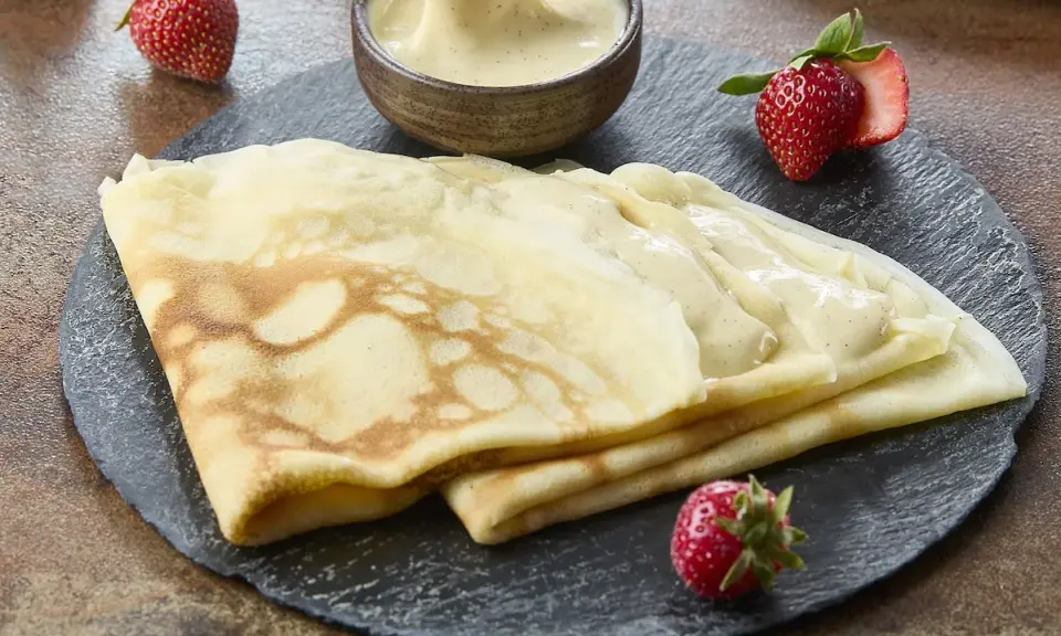 Délicieuses crêpes de riz garnies de crème vanillée, accompagnées de fraises fraîches. Un délice gourmand.