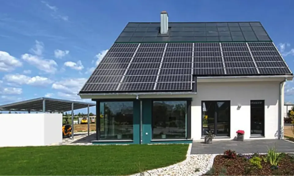 Ein modernes, energieautarkes Haus mit Solarmodulen auf dem Dach und einer Photovoltaik-Anlage auf dem Carport.