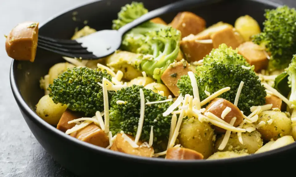 Ein schnelles Gericht mit Kartoffeln, Brokkoli und Würstchen, bestreut mit Käse. Perfekt für Rezepte mit wenig Zutaten.