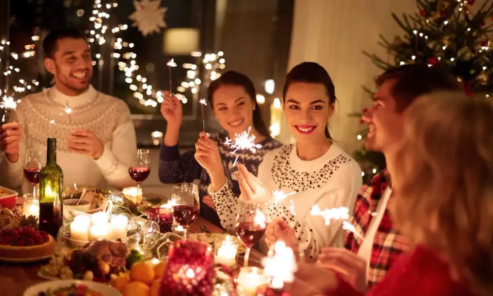 Vänner firar jul i Sverige med tomtebloss och en festlig middag.
