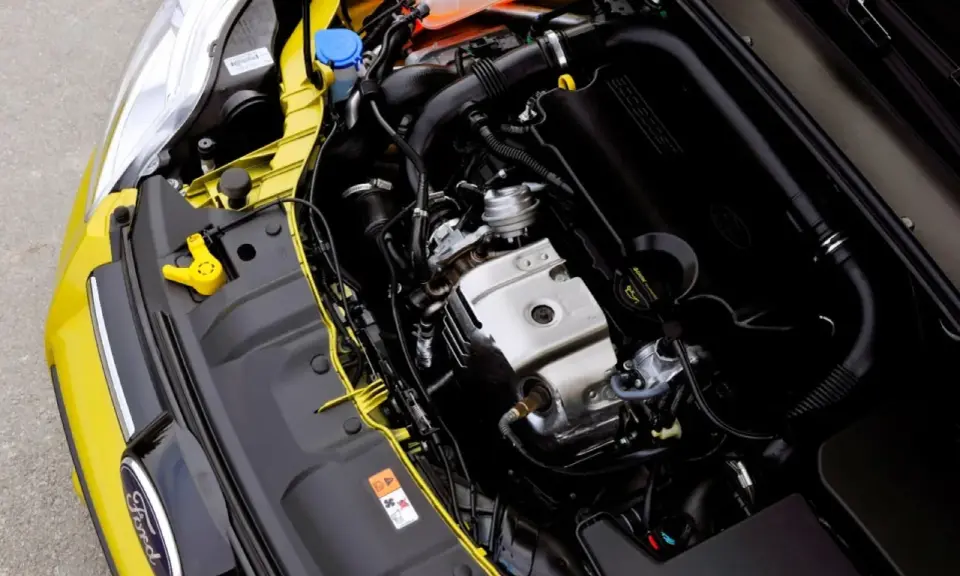 Silnik EcoBoost w żółtym Fordzie, z widocznym logo Ford i elementami układu dolotowego.