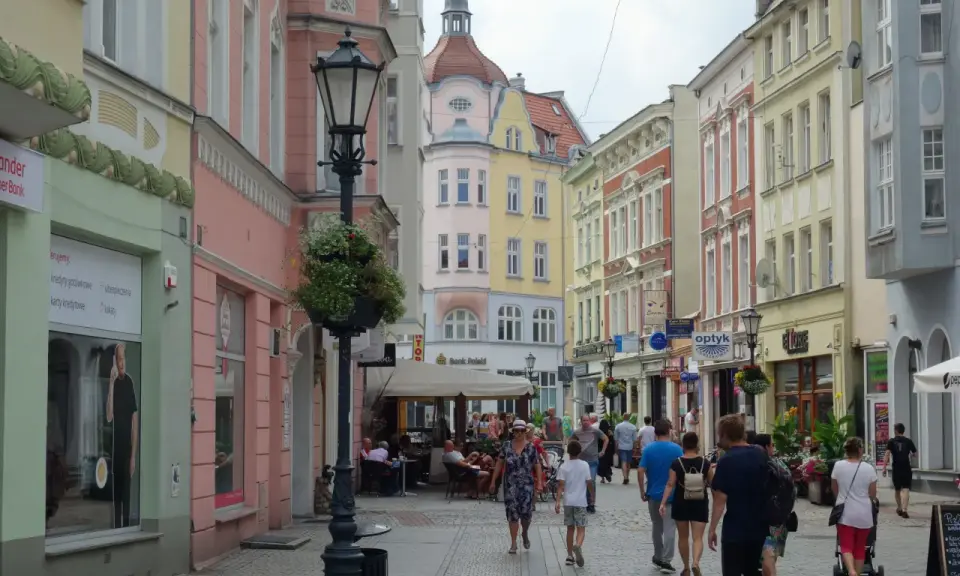 Kolorowa ulica z kamienicami, latarnią i ludźmi spacerującymi po deptaku. To idealne miejsce na odkrywanie zielona góra atrakcje.