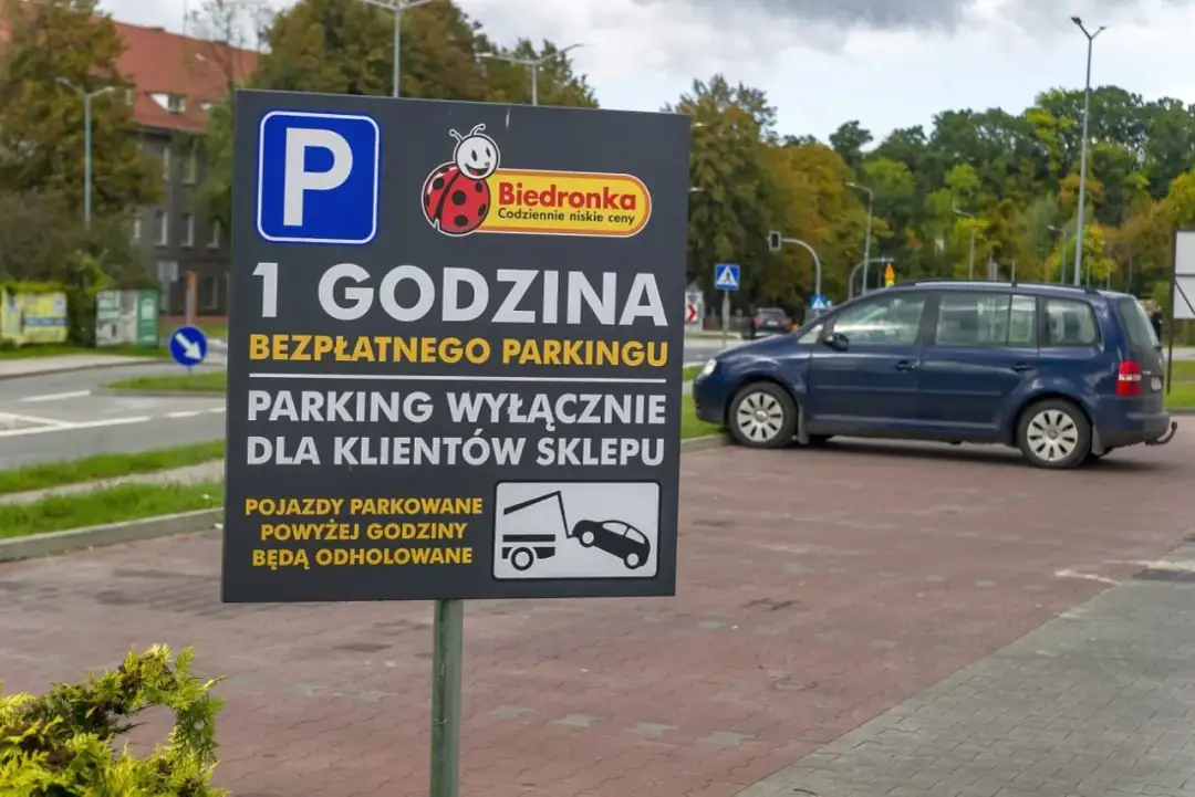 Tablica informuje o 1 godzinie bezpłatnego parkingu dla klientów Biedronki. Pojazdy parkowane powyżej godziny będą odholowane.