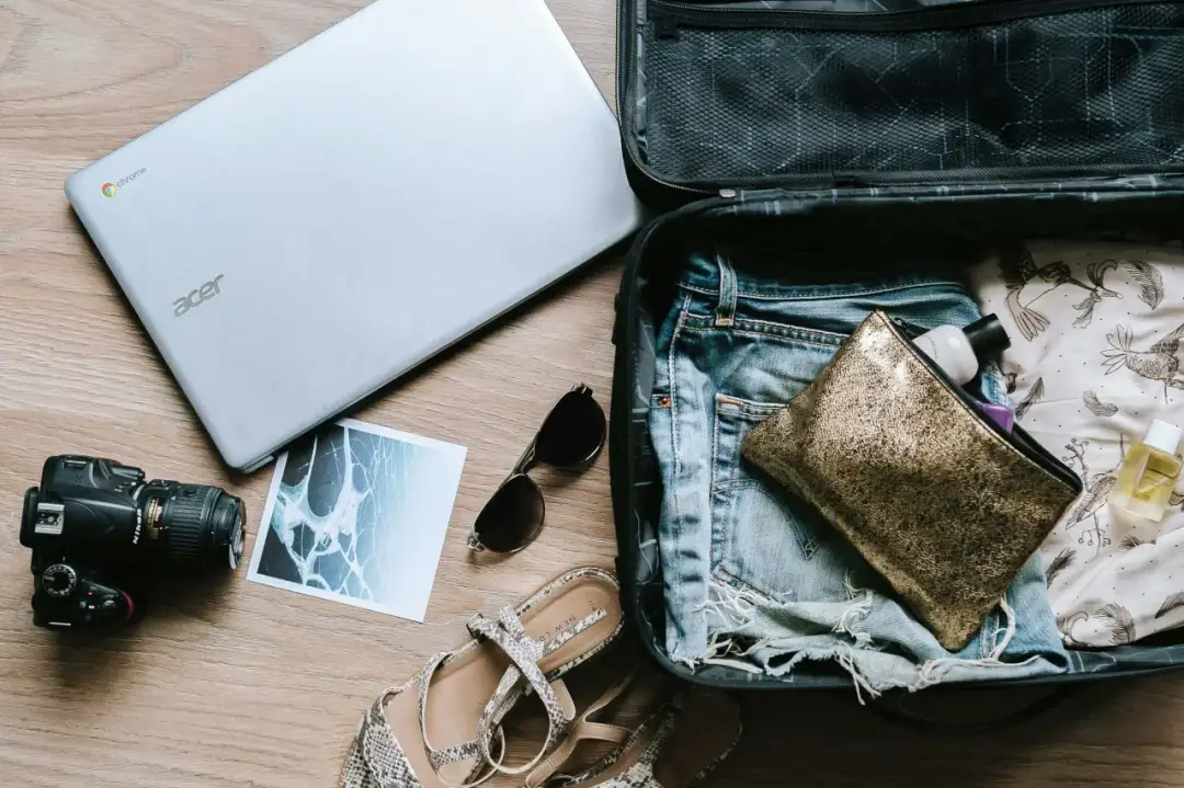 Pakowanie do Dubaju: laptop, aparat, okulary, buty, kosmetyczka i ubrania.