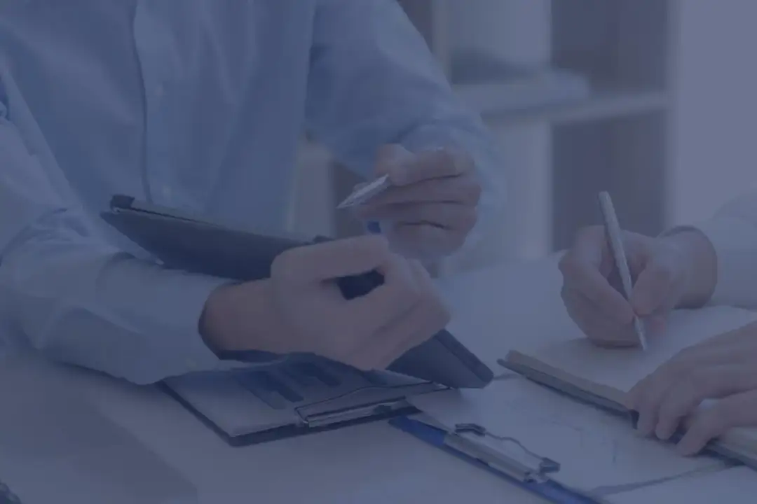 Dwie osoby przy biurku analizują dokumenty. Kluczowe różnice między oddelegowaniem a podróżą służbową dla PIP.