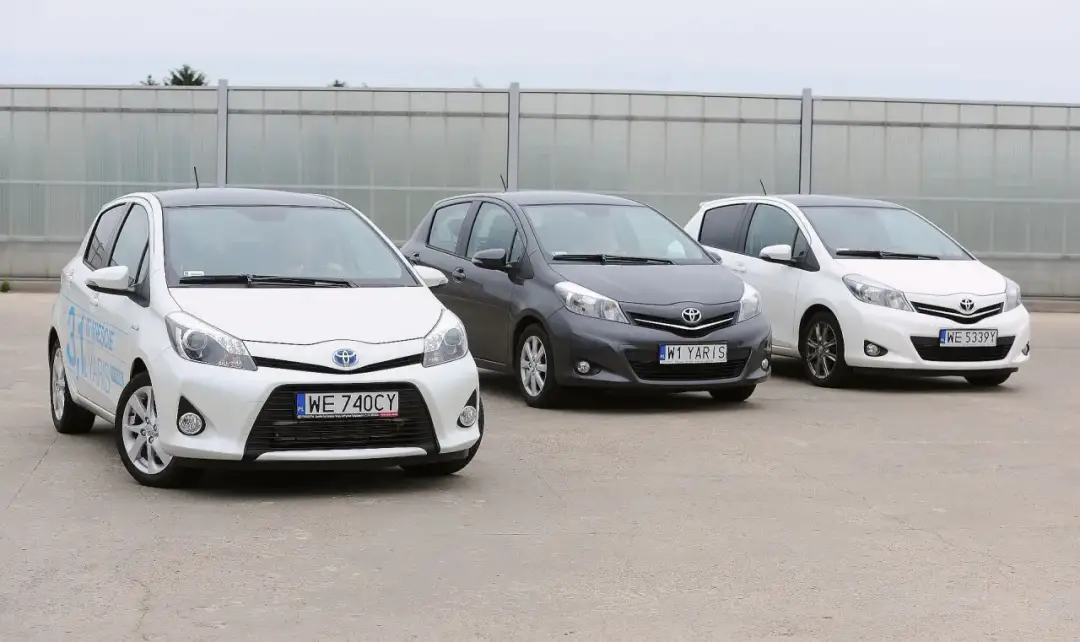 Trzy Toyoty Yaris, idealne na najmniej awaryjne samochody do 30 tys. zł, zaparkowane na placu.
