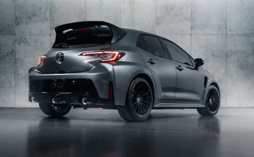 Szary Toyota Corolla GR z agresywnym spojlerem i podwójnymi końcówkami wydechu, gotowy do akcji.