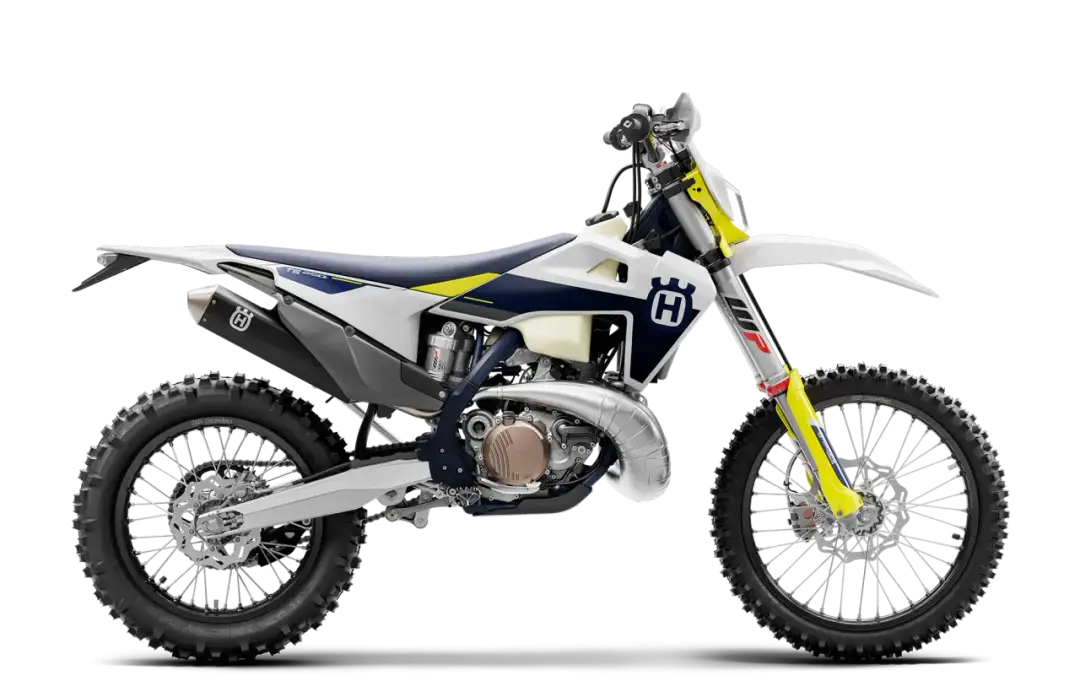 Motocykl Husqvarna TE 250 2T w białej, granatowej i żółtej kolorystyce, widok z boku.
