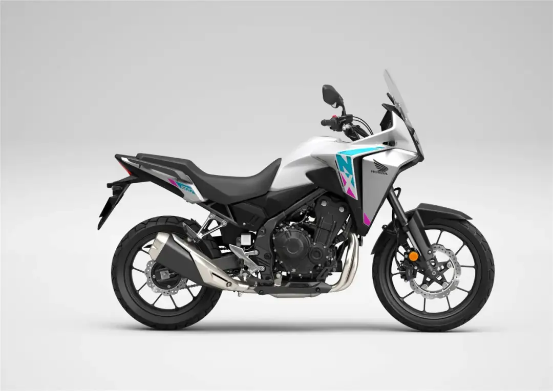 Biały motocykl Honda NX 500 z niebiesko-różowymi akcentami, gotowy na przygodę.