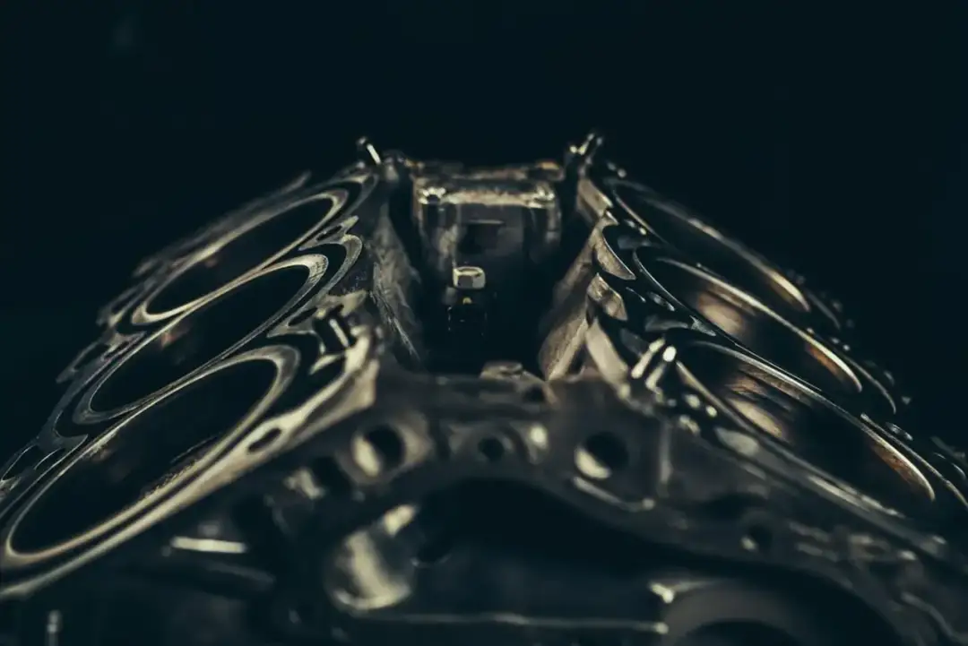 Metalowa głowica silnika z widocznymi cylindrami. Zastanawiasz się, ile wytrzyma głowica po regeneracji?
