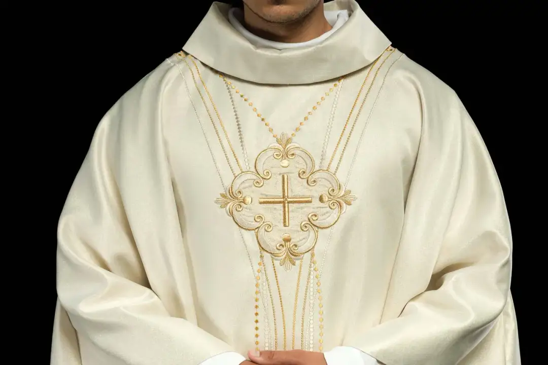 Biała szata z haftowanym złotym krzyżem i ozdobnymi sznurami, symbolizująca liturgia męki pańskiej.