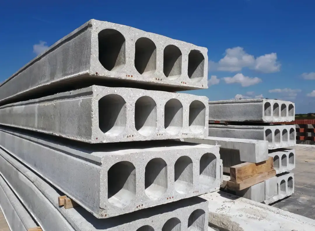 Stos betonowych płyt stropowych kanałowych pod błękitnym niebem. Gotowe do budowy domu.