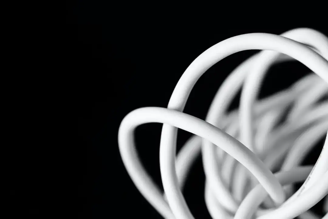 Biały, zwinięty kabel antenowy na czarnym tle. Czy kabel antenowy można łączyć? Tak, ale zależy od typu.