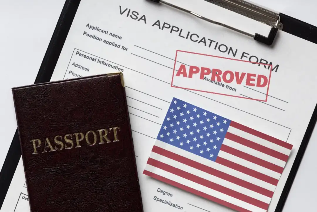 Paszport i formularz aplikacji o wizę do USA z pieczątką "APPROVED".