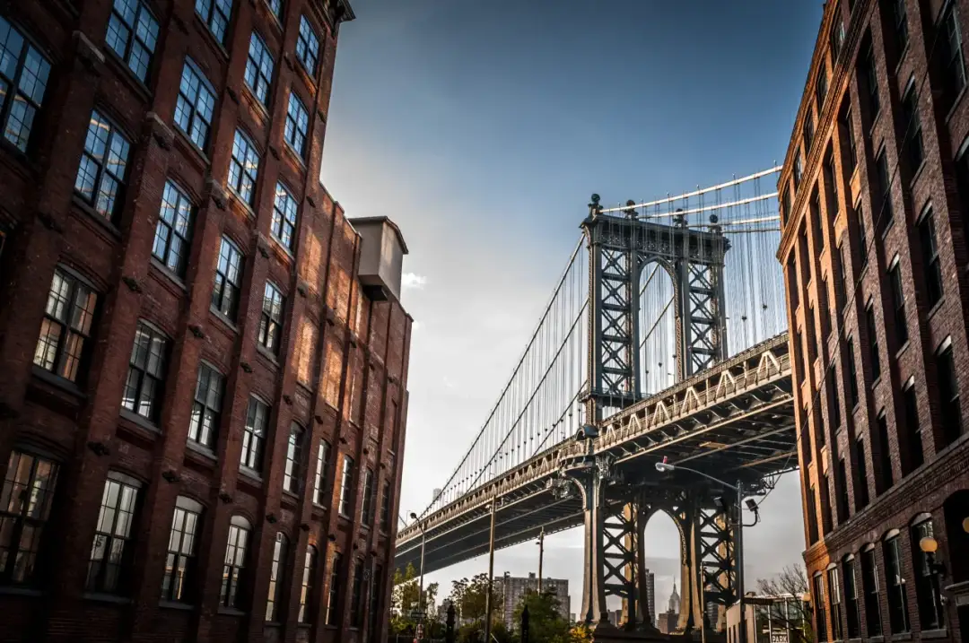 Ceglane budynki i majestatyczny most Manhattan Bridge tworzą malowniczy widok. Czy Brooklyn jest bezpieczny? Ten widok sugeruje spokój i piękno.