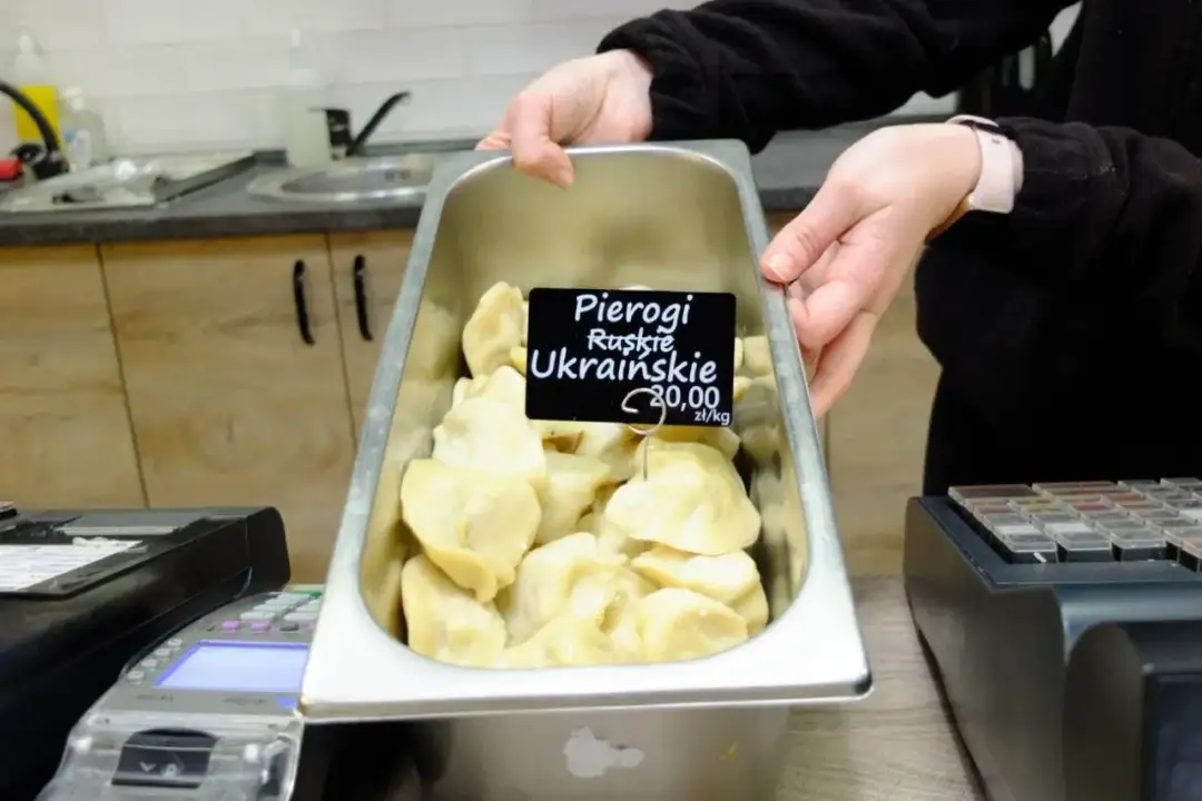 Taca pełna pysznych pierogów ukraińskich, gotowych do sprzedaży. Cena 20,00 zł/kg.