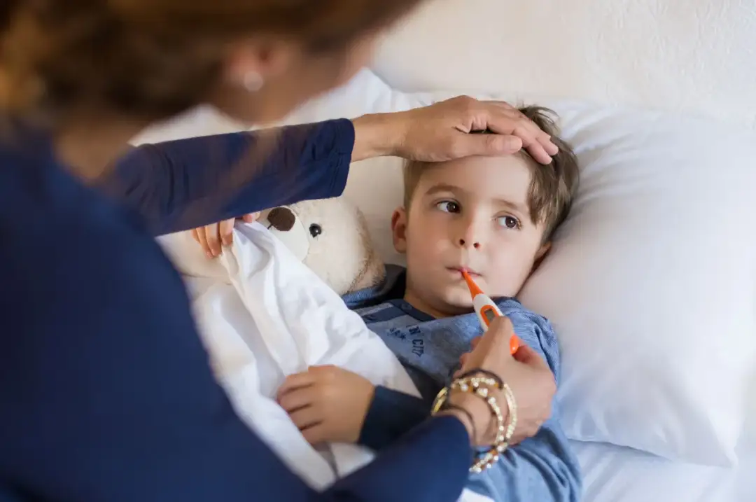 Mama mierzy temperaturę choremu synkowi. Czy można kąpać dziecko gdy ma gorączkę?